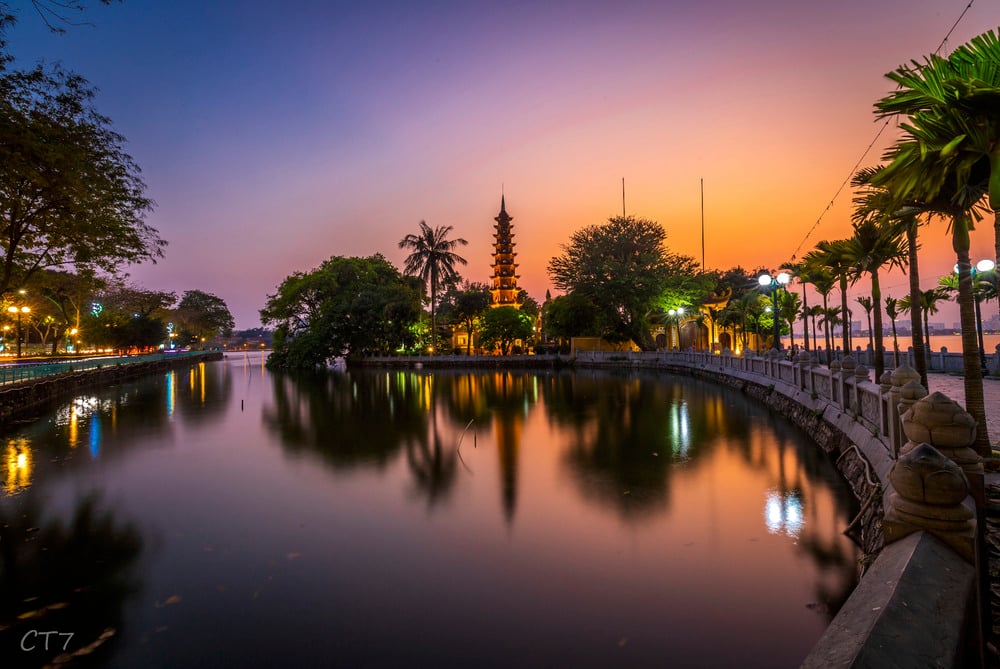 Experience spiritual calm and natural beauty as sunset bathes Trấn Quốc Pagoda in warm light