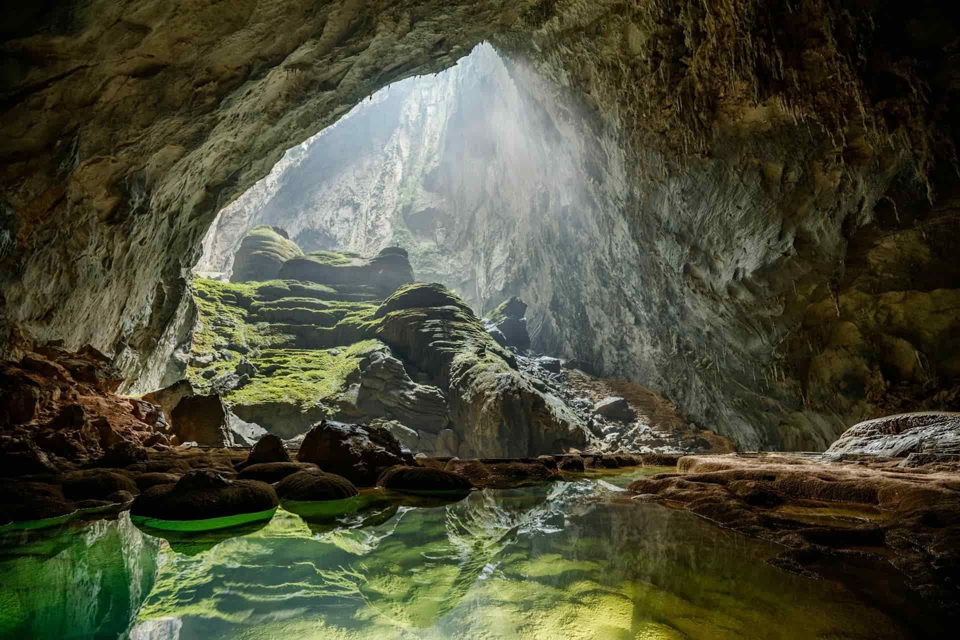Sunbeams pierce through a skylight in Son Doong