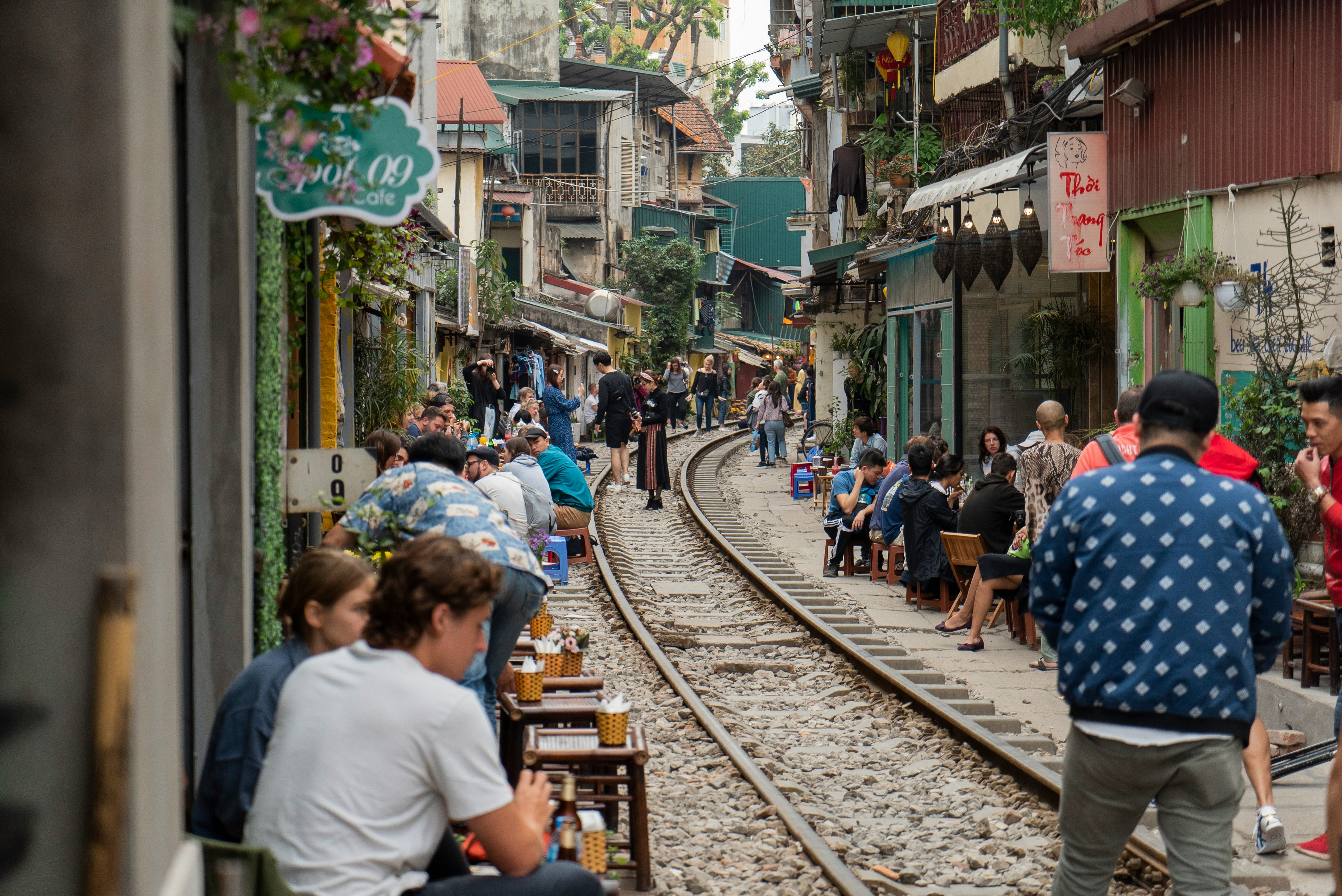 Café along Hanoi Train Street with tourists sitting near the railway tracks