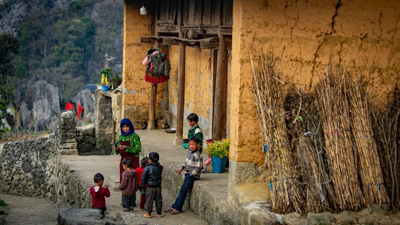 H’mong woman carrying her child, dressed in traditional clothing, in the highlands of Ha Giang, Vietnam