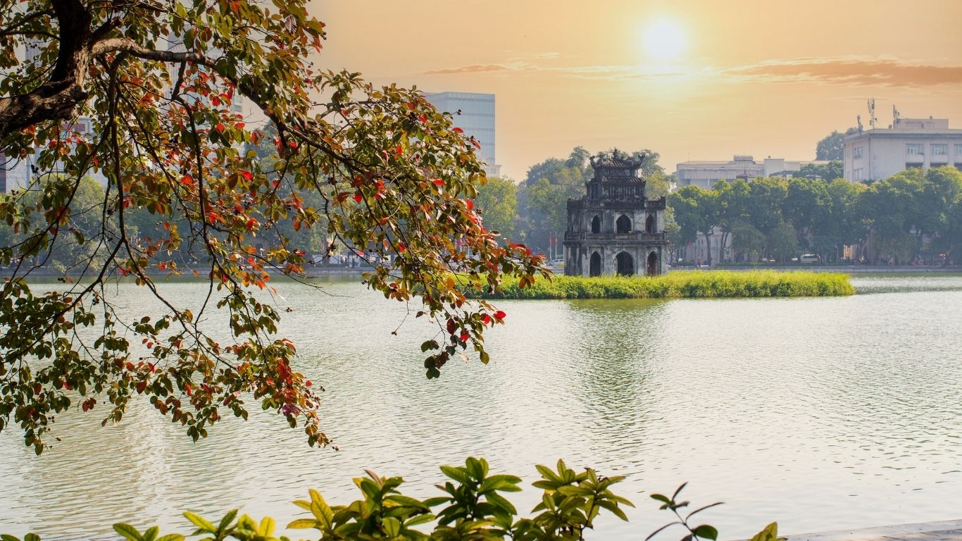 Sunrise over Hoan Kiem Lake with Turtle Tower with autumn leaves