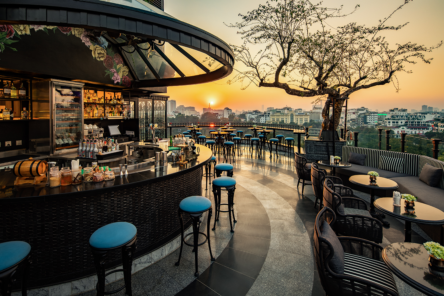Golden hour in Hanoi, captured from a stylish rooftop bar with skyline views